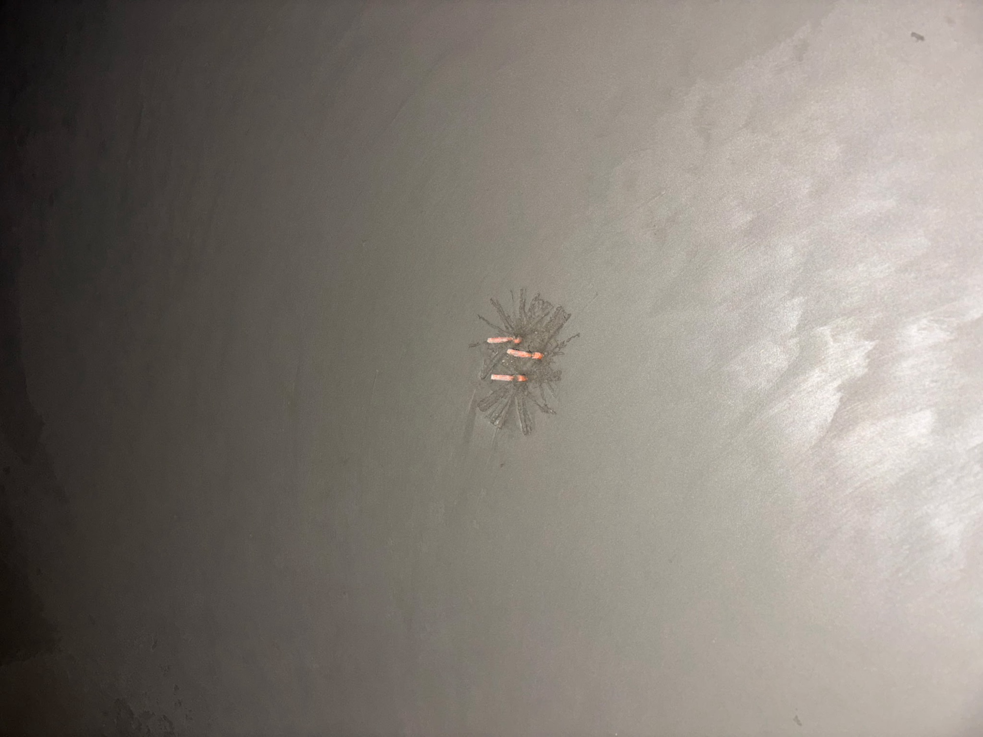 Finished concrete slab close-up — four orange Stub-EASE II™ talons visible above the surface after troweling, marking the stub-up location